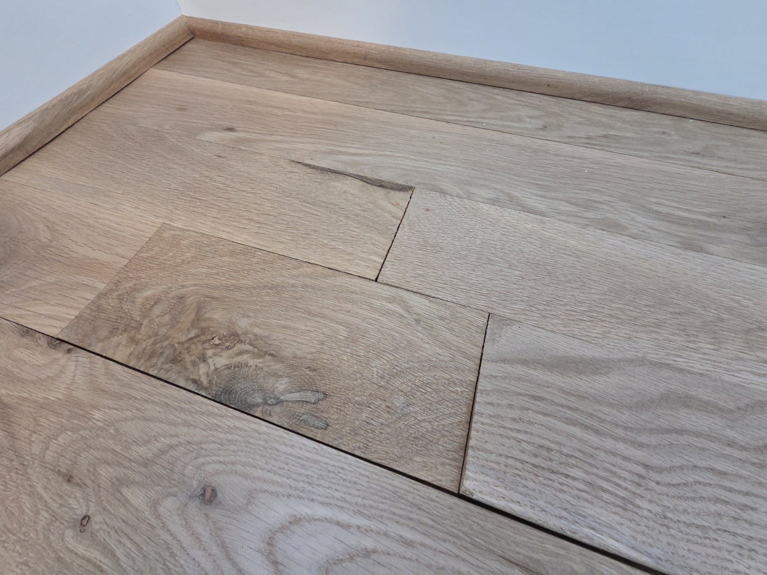 Moisture damage project in Goodlettsville, Tennessee, showing raised flooring planks and separated seams near a wall