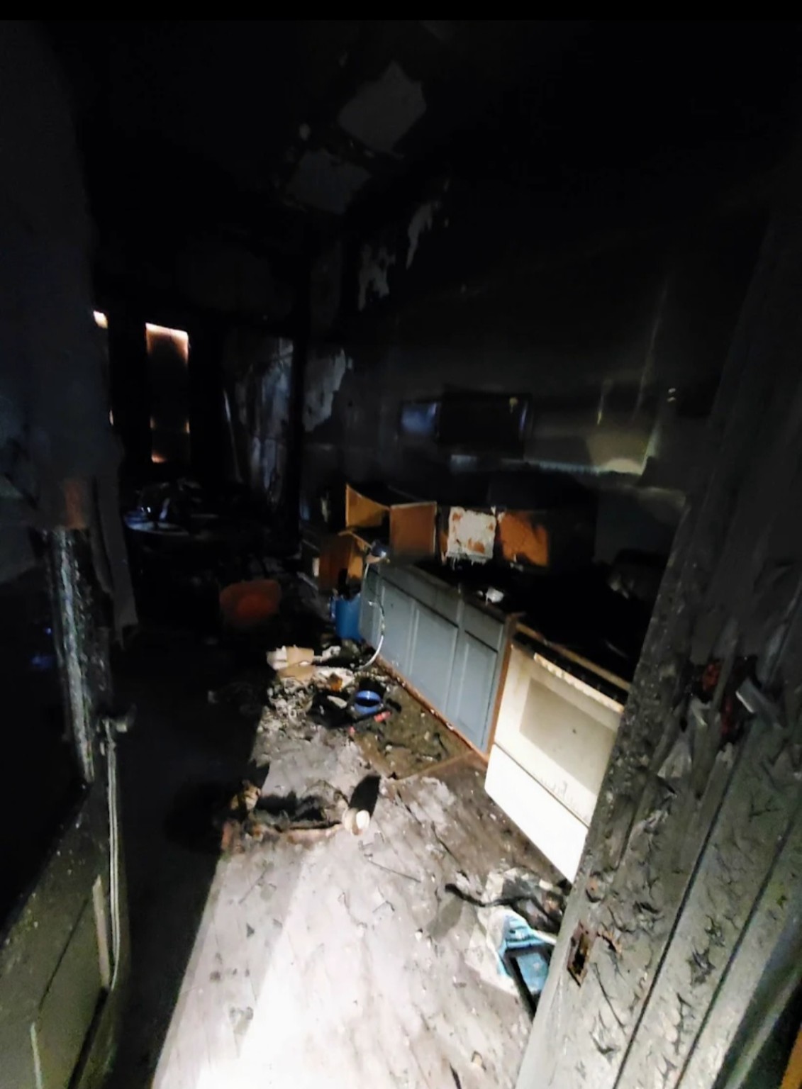 Fire-damaged kitchen in Hendersonville, Tennessee, with charred walls, damaged cabinets, and debris before cleanup
